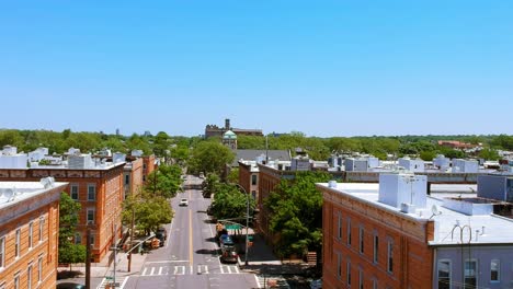 Glendale-Queens-buildings-and-trees,-aerial-blue-sky,-cars-driving-by