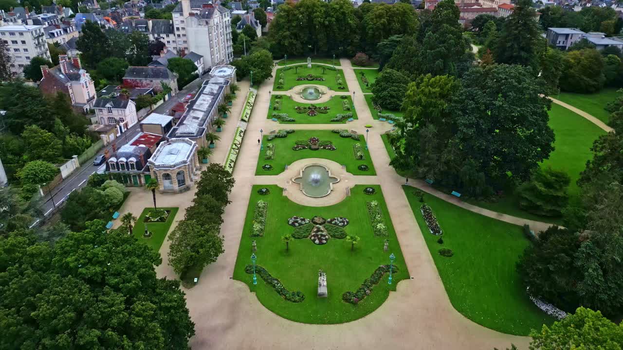 Drone flying over Thabor gardens with fountains and flower beds, Rennes in France. Aerial drone backward