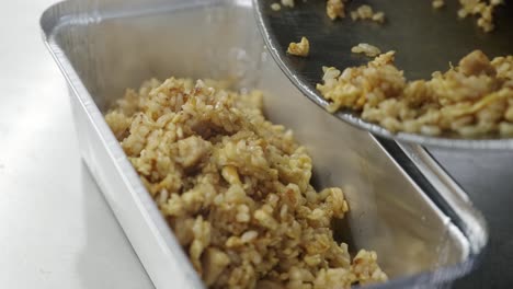 a dish of rice and meat packed in a bowl decorated with green onions