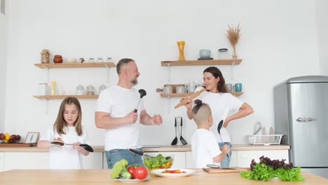 insanely happy family with two children dancing in the kitchen with a modern interior insanely happy family with two children dancing in the kitchen with a modern interior dancing family great mood