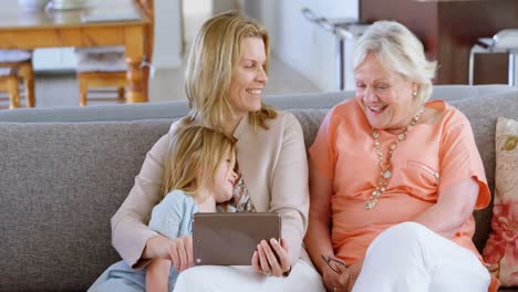 multi-generation family using digital tablet in living room 4k