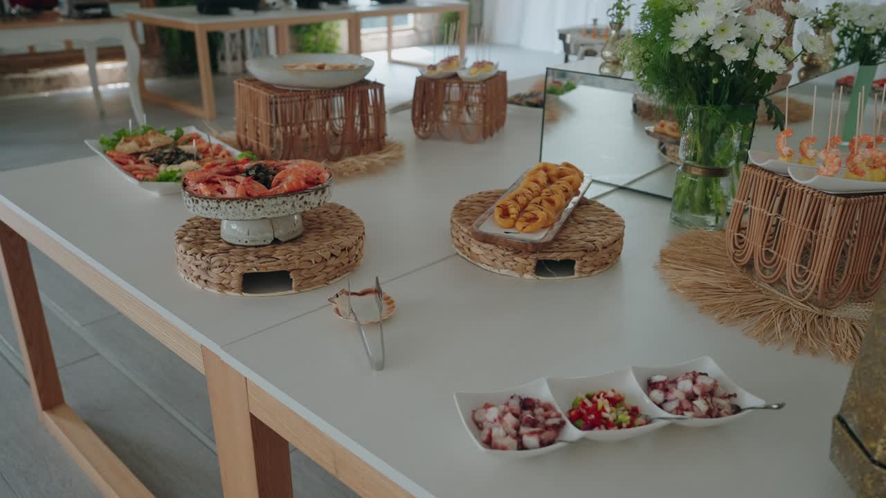 Variedad de mariscos y aperitivos dispuestos en una mesa de buffet decorada