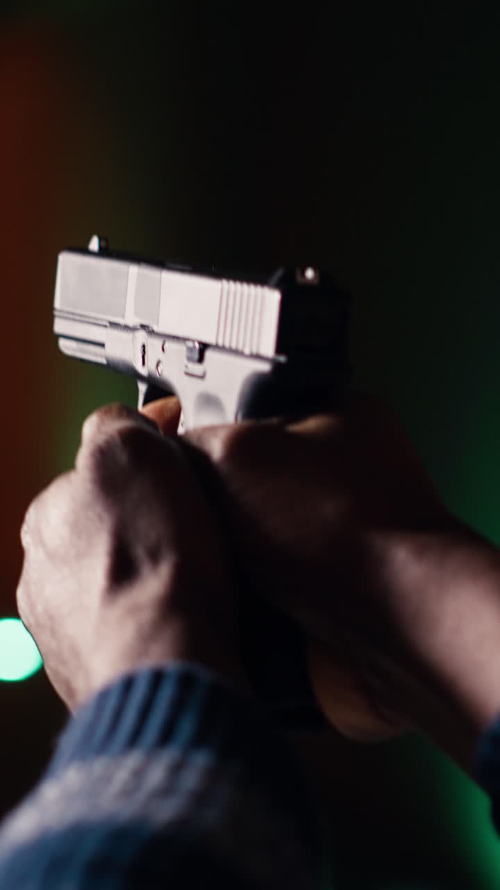 Vertical video Man holding pistol at indoor shooting range, close up
