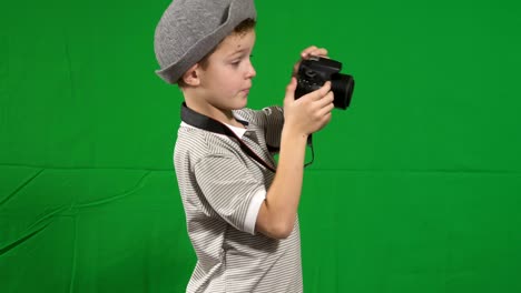 little cute boy wearing hat takes photo at chroma key background