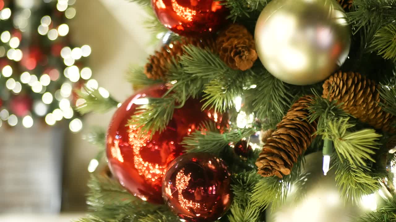 primer plano de un árbol de navidad al aire libre decorado festivamente con bolas rojas brillantes en un fondo de hadas brillantes borrosas. luces de guirnaldas desenfocadas, efecto bokeh. feliz navidad y feliz concepto de vacaciones.