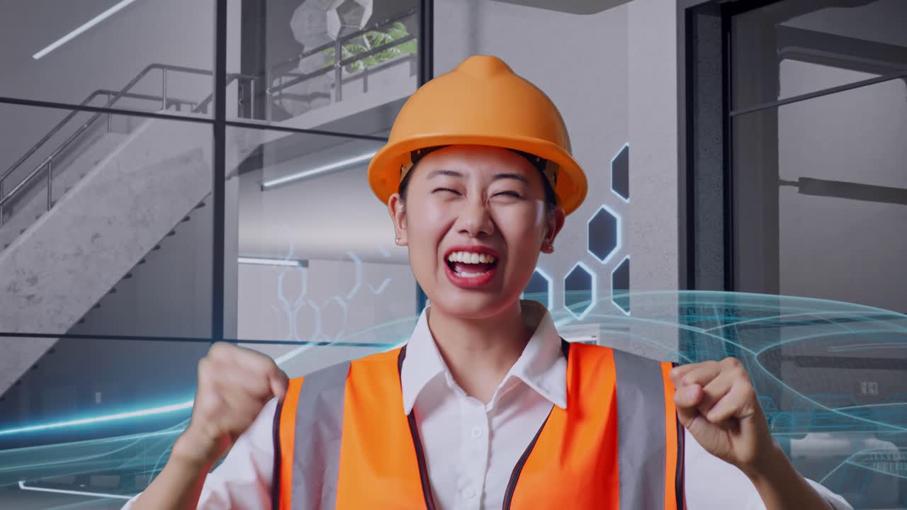 안전 헬을 착용한 아시아 여성 엔지니어가 골과 춤을 치며 전기 차량의 개념을 축하하고 있습니다.