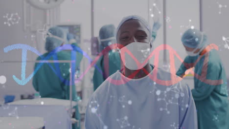 animation of dna strand and molecules over smiling african american male surgeon in theatre