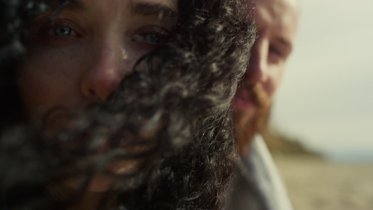 этническая женщина смотрит в камеру на фоне природы. пара наслаждается дующим ветром