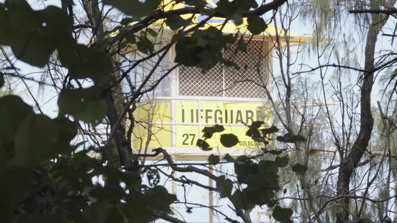 Lifeguard tower stand on the beach behind some bushes in Australia.