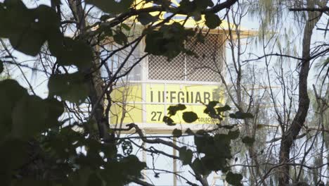 lifeguard tower stand on the beach behind some bushes in australia.