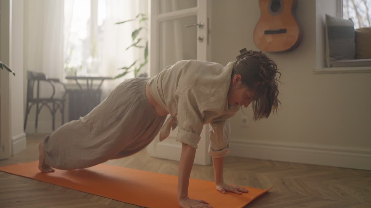 mujer haciendo postura de yoga en casa