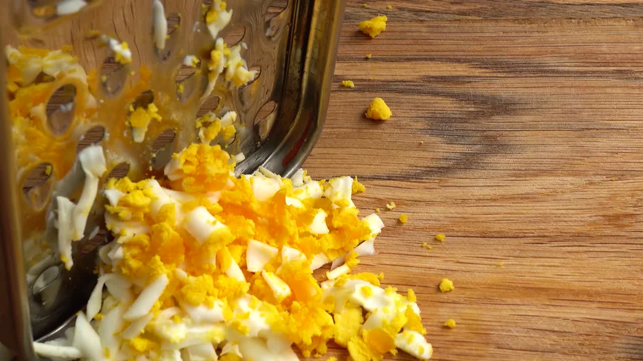 Le cuisinier râpe un œuf. Travail du cuisinier