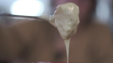 fondue - mano da vuelta a un trozo de pan baguette con queso caliente derretido, cámara lenta