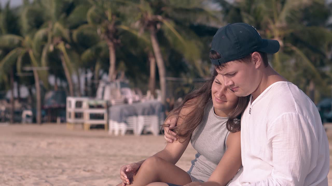 잘생긴 남자가 긴 어두운 머리카락을 가진 아름다운 여자를 포옹합니다.