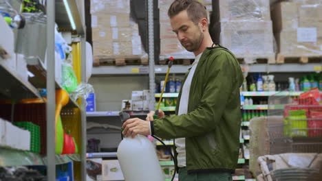 hombre inspeccionando el pulverizador de jardín en una tienda de mejoras para el hogar