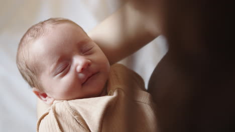 mother holding sleeping newborn baby