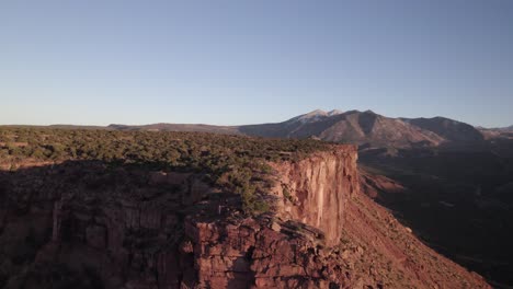 Aerial-retreats-from-La-Sal's-Adobe-Mesa-cliffs-at-evening-golden-hour