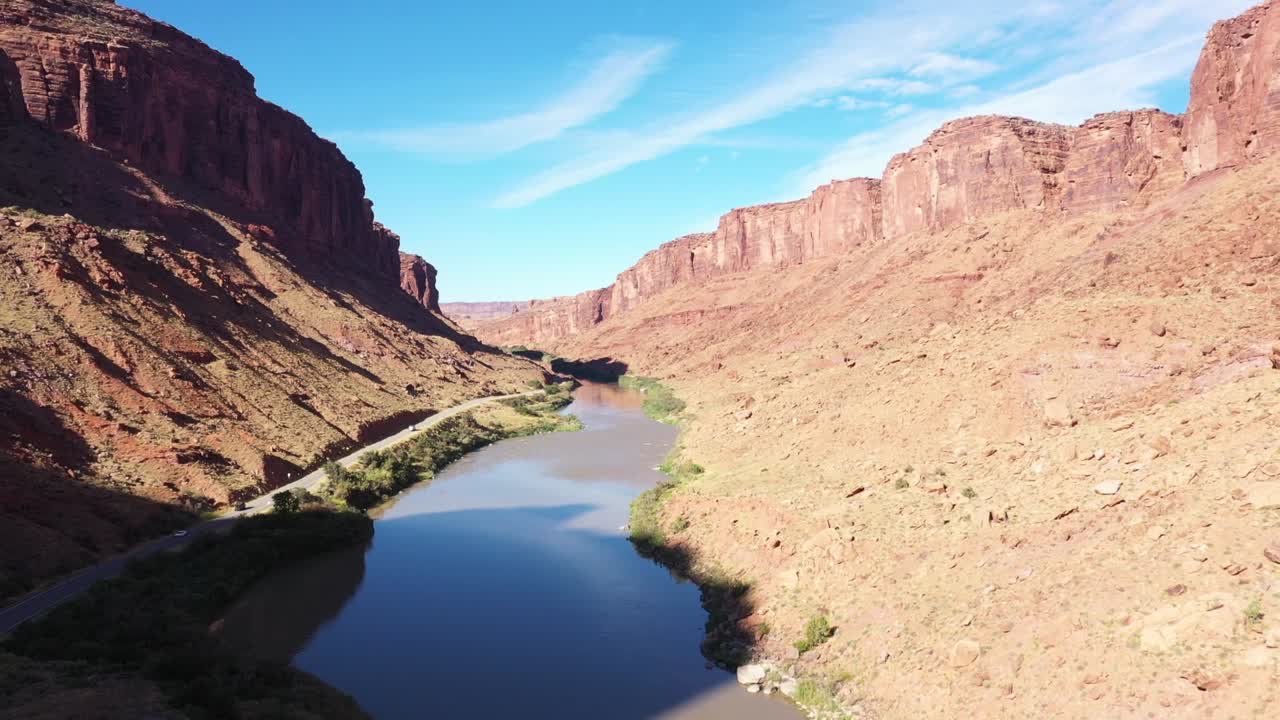 volando a lo largo del río colorado en utah cerca de moab y arches parque nacional con cielo despejado y sol