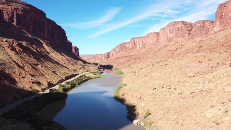 Volando-A-Lo-Largo-Del-Río-Colorado-En-Utah,-Cerca-Del-Parque-Nacional-Moab-Y-Arches,-Con-Cielos-Despejados-Y-Sol