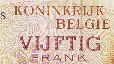 macro pan across a belgian 50 francs note, highlighting “koninkrijk belgië” and “vijftig frank” text