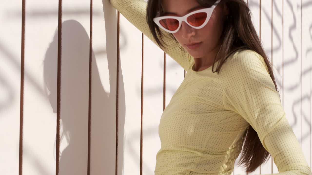 брюнетка позирует на деревянном фоне на пляже.