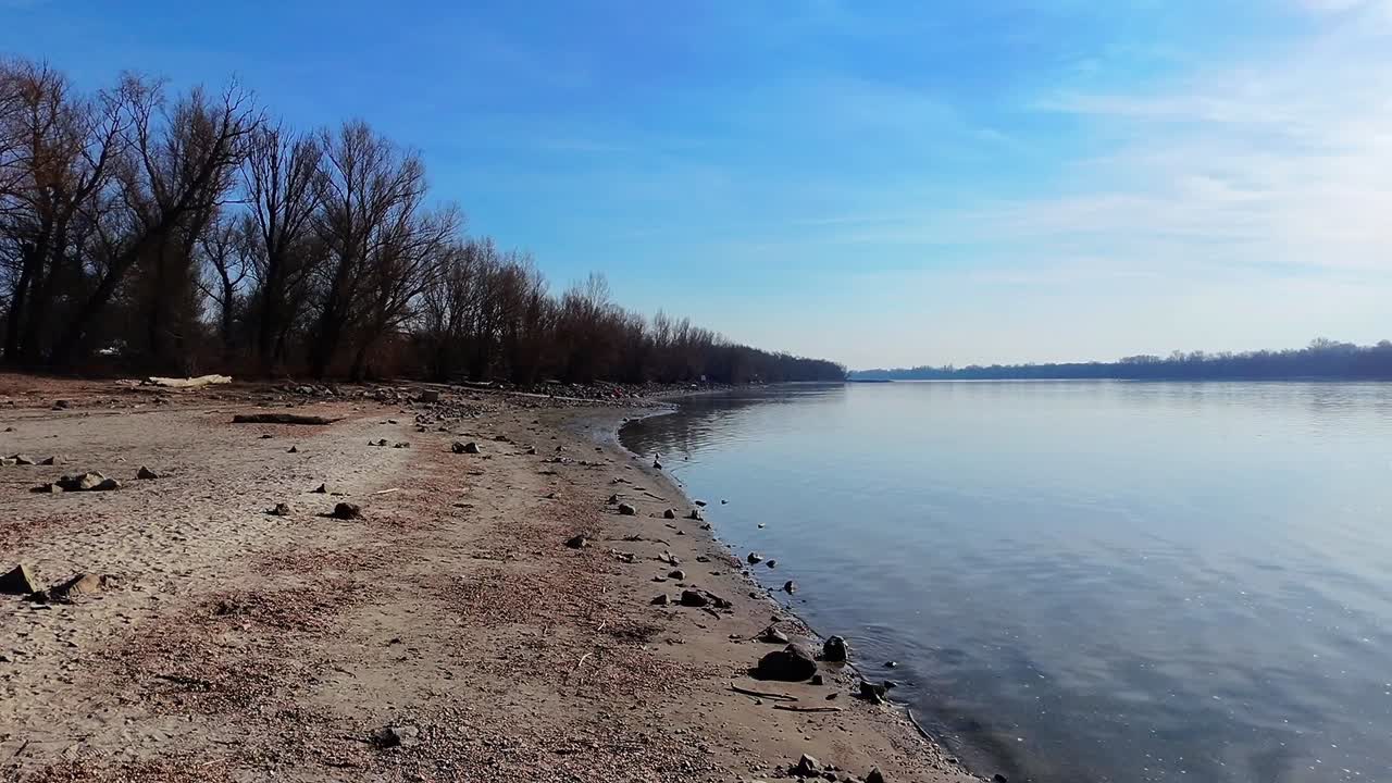 Prachtig rivieroevertafereel in Szodliget, Donau, Hongarije, met kalm water, kale bomen en een heldere lucht, wat sereniteit oproept. De stille schoonheid van de natuur is vastgelegd in deze opvallende, vredige compositie.