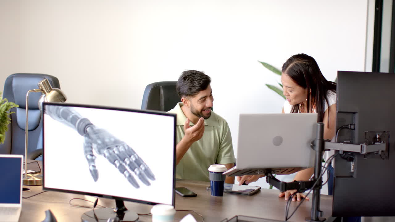 Discussing robotic arm design, colleagues in modern office collaborating with laptops