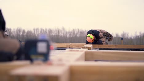 construction workers using laser level on wooden beams