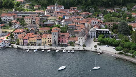 Aerial-View-Of-A-Picturesque-Waterfront-Town-With-Colorful-Buildings-Bordering-Pella-Lake