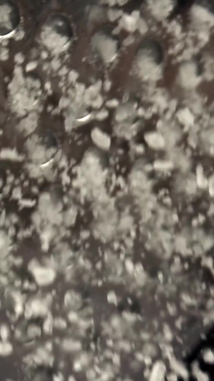 Macro Shot of White Crystals Falling Through Metal Grater Holes