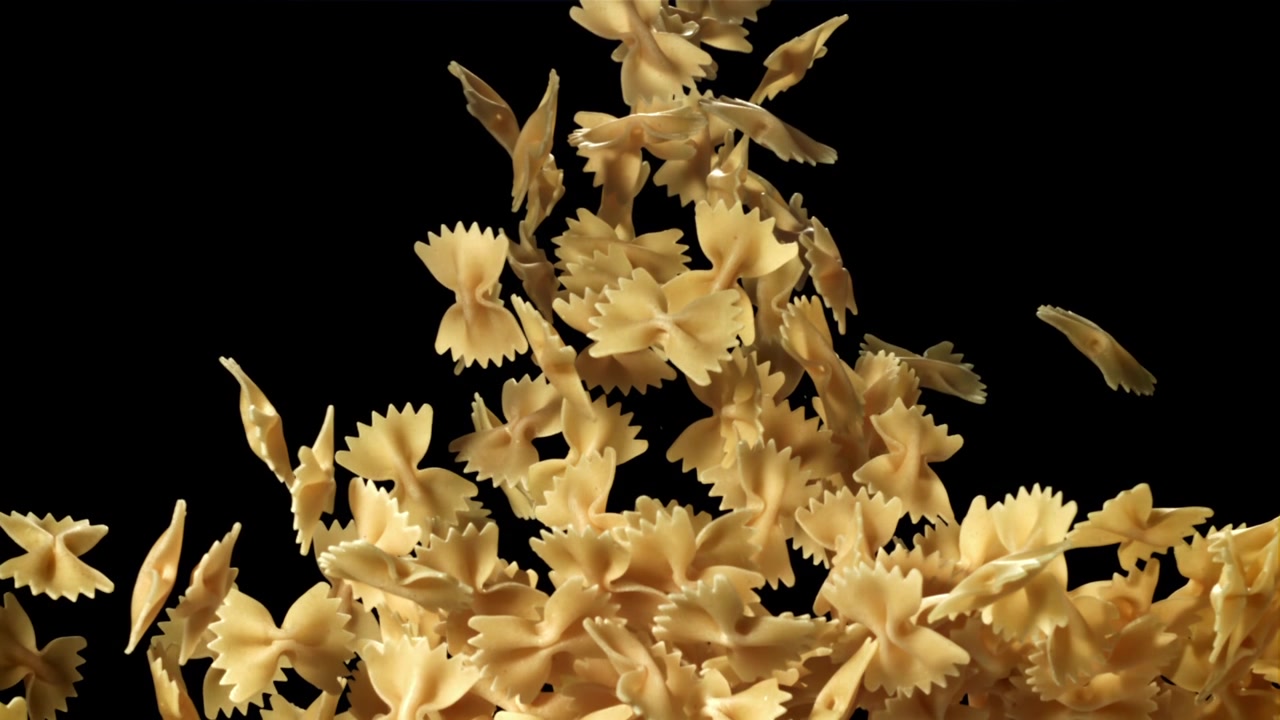 Pasta farfalle che cade al rallentatore su sfondo nero