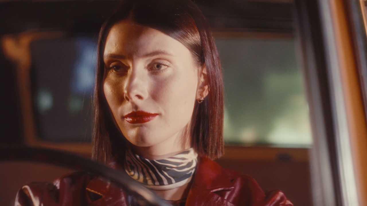 Feminine Woman Driving Classic Retro Car on City Street at Night