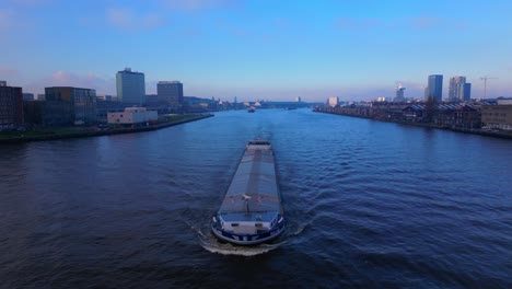 Vuelo-Aéreo-Sobre-Un-Barco-Cisterna-Procedente-Del-Canal-Del-Mar-Del-Norte-En-Ámsterdam,-Crepúsculo