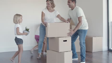 positive parents and two daughters packing things for moving