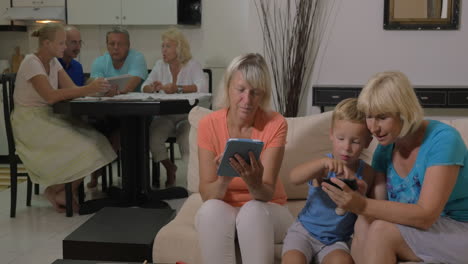 Grandmothers-and-grandchild-with-electronics-at-home