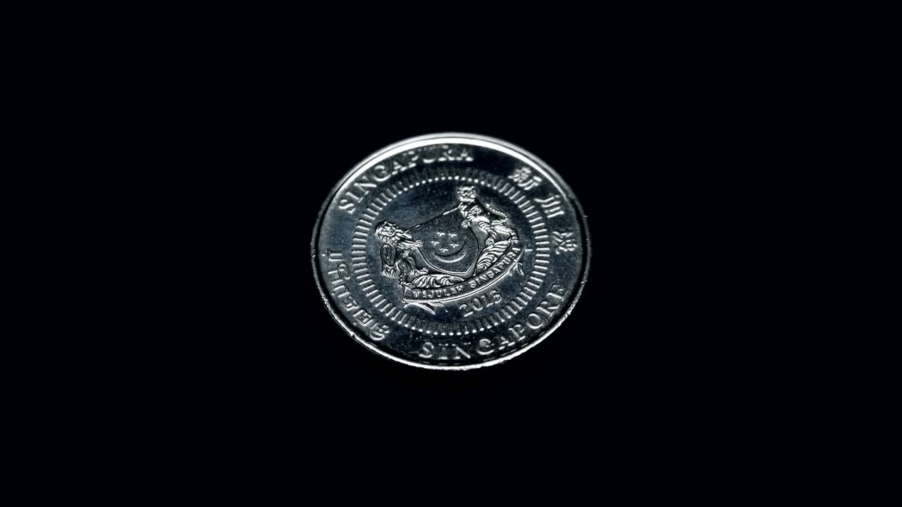 la moneda de singapur de 50 centavos gira sobre un fondo negro. macro. primer plano