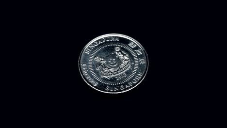 la moneda de singapur de 50 centavos gira sobre un fondo negro. macro. primer plano