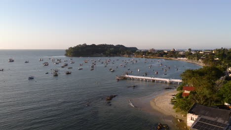 Praia do Trapiche beach bay with fishing boats anchored near pier in relaxed atmosphere, Penha, Santa Catarina, Brazil
