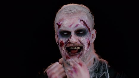 hombre siniestro disfrazado de halloween zombie loco escuchando música, sonriendo bailando a la música disco