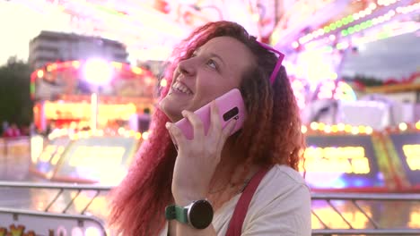 happy woman talking on smartphone at the fair