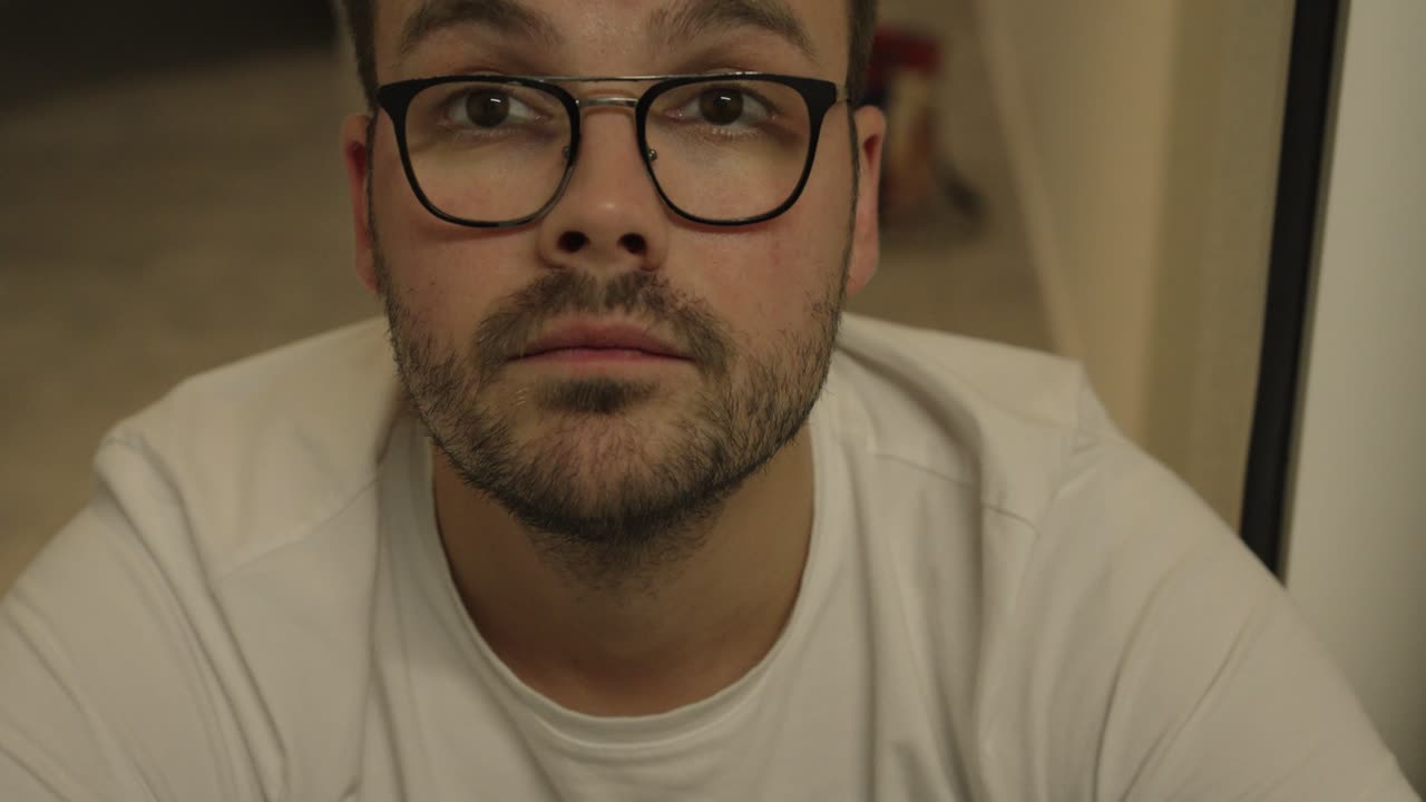 Primo piano di un uomo che appoggia la testa sulla mano, fissando lo sguardo verso l'alto con un'espressione delusa. Cattura frustrazione, riflessione e affaticamento emotivo.