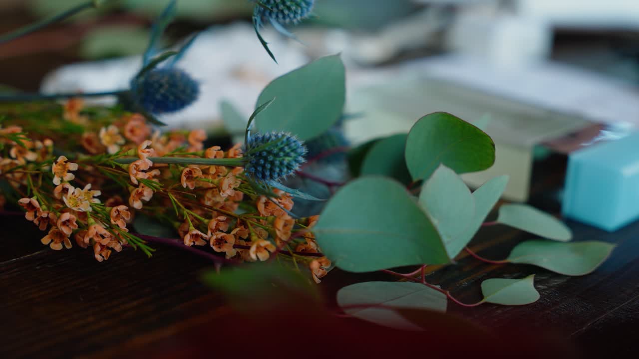 A close-up focusing on a blue thistle in the wedding floral arrangement, showcasing natural wedding decor and rustic charm.