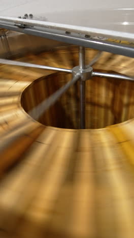 honey removal machine rotating the frames with organic honey. harvesting healthy product on the rural bee farm. close up. vertical video