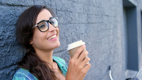 Una-Chica-Atractiva-Está-Tomando-Un-Café-Y-Sonriendo-A-La-Cámara.-