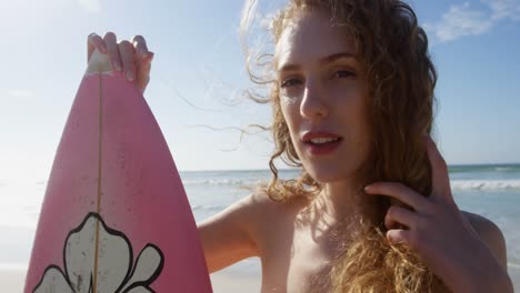 female surfer standing with surfboard at beach 4k