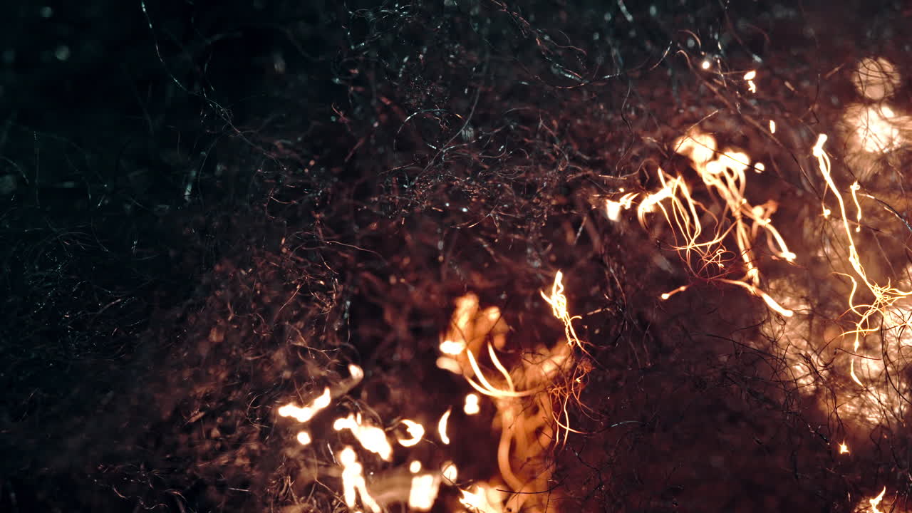 Dark macro shot of a textured surface with particles resembling fire or sparks