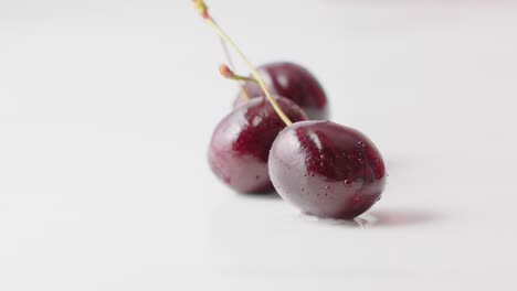 las cerezas rojas húmedas cayendo