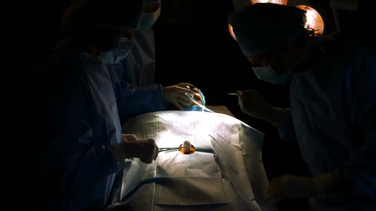 Surgeons performing operation in operation room