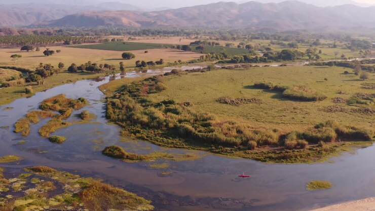 Vista aerea di un kayak solitario che pagaia nel suggestivo fiume della valle di Monterry, nella natura selvaggia de La Huasteca, Messico
