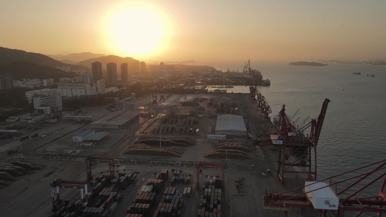 воздушное видео заката показывает кран и контейнер на причале с верхнего угла обзора